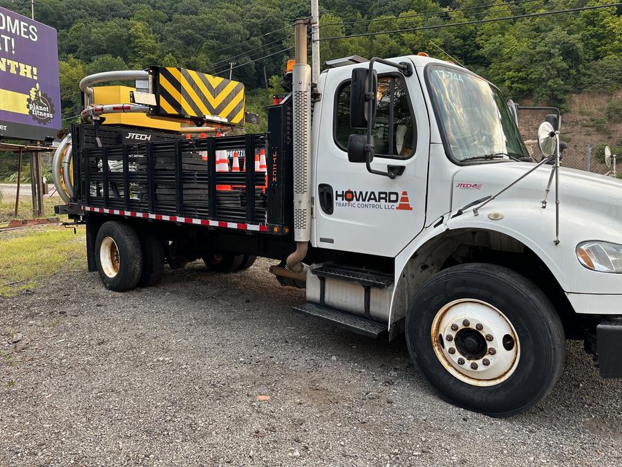 Howard Traffic Control flatbed truck carrying a truck-mounted attenuator and cones